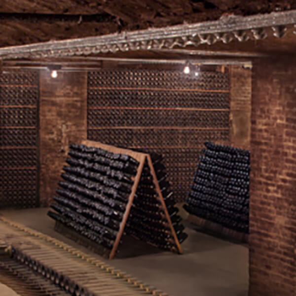 Bottles in pupitres, or riddling racks.