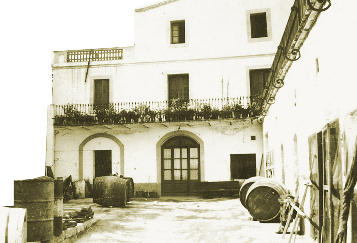 Early Freixenet headquarters, a white colonial style building with wine barrels in front.