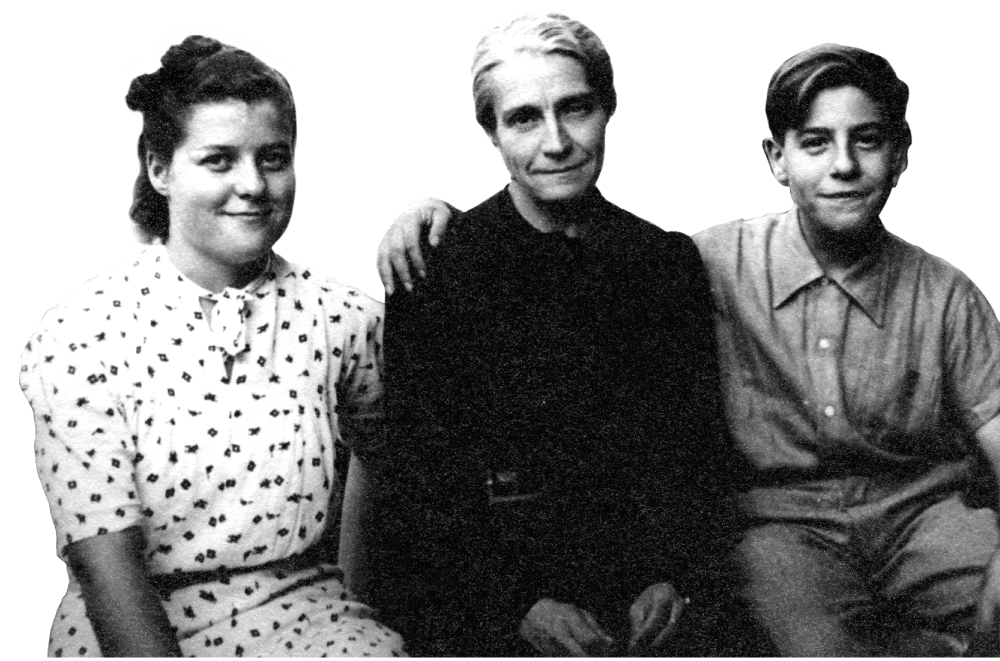 Doris Ferrer sits, flanked by her oldest daughter wearing a polka dot dress, and an unidentified boy sits on her other side.